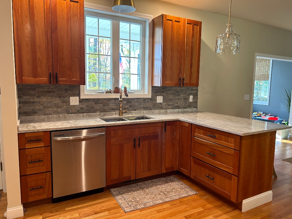Dated cherry kitchen cabinets before cabinet refacing in Belchertown MA — old raised panel doors and dark wood tone