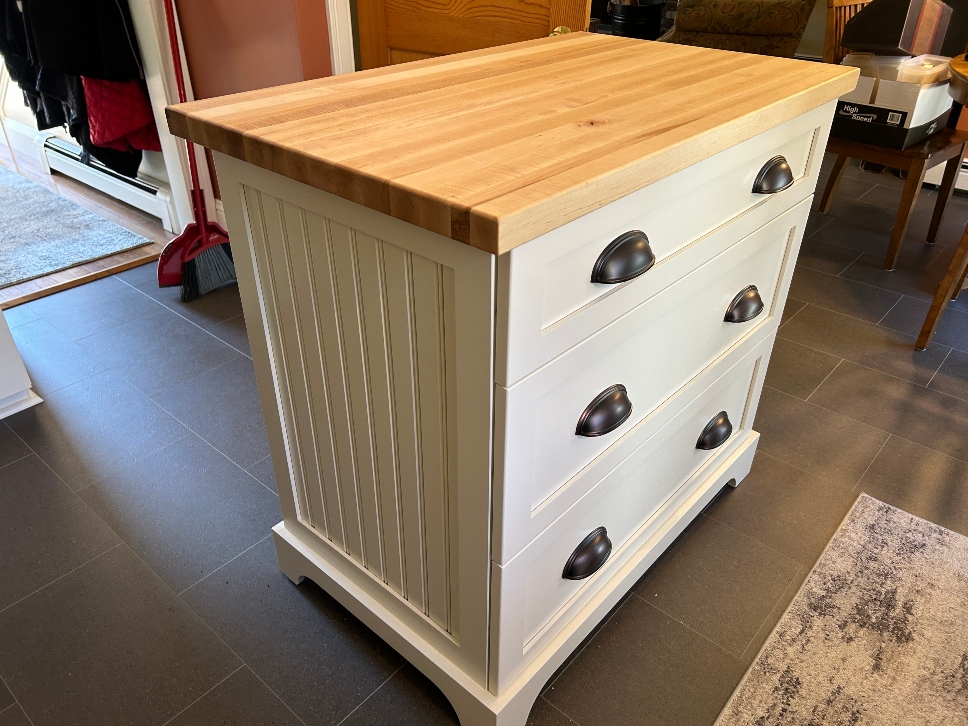 Custom kitchen island with butcher block top, painted base cabinets, and drawer storage — built to fit the space