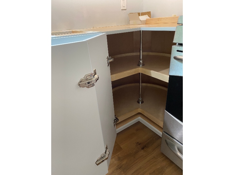 New wood lazy susan installed in corner kitchen cabinet