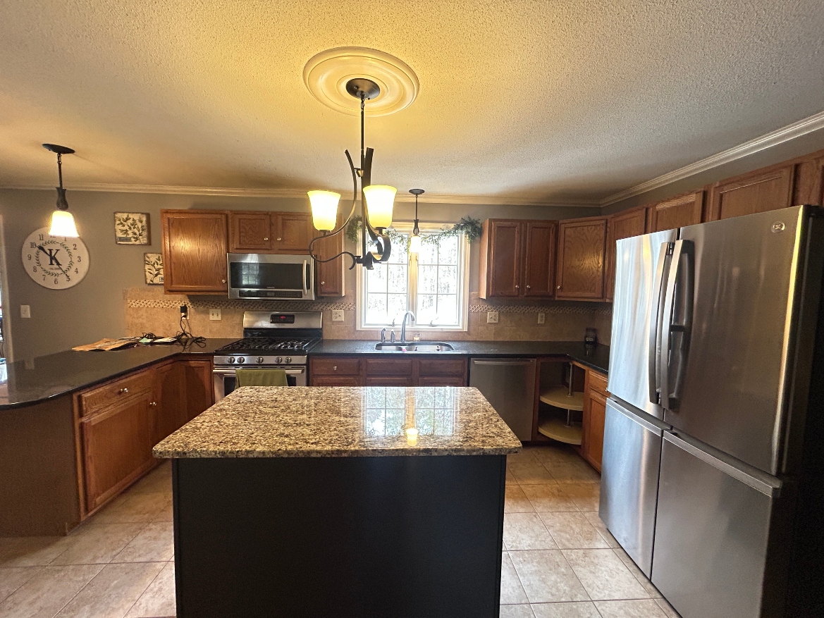 Before cabinet refacing in Ludlow MA — dated honey oak kitchen cabinets with raised panel doors before transformation