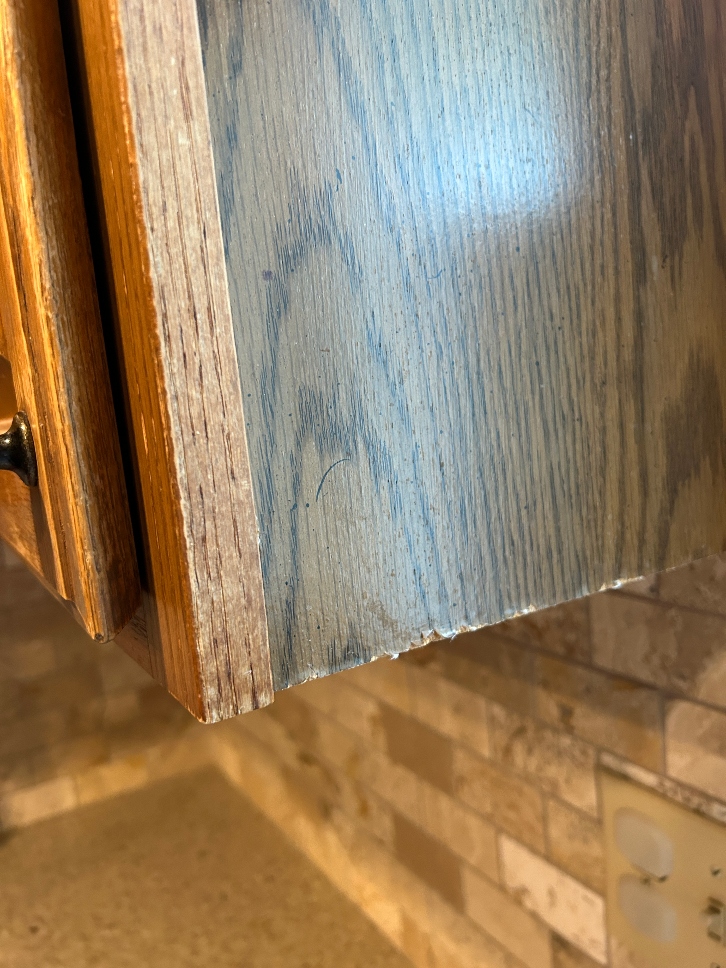 Particle board cabinet with damaged sides — should be refaced not painted